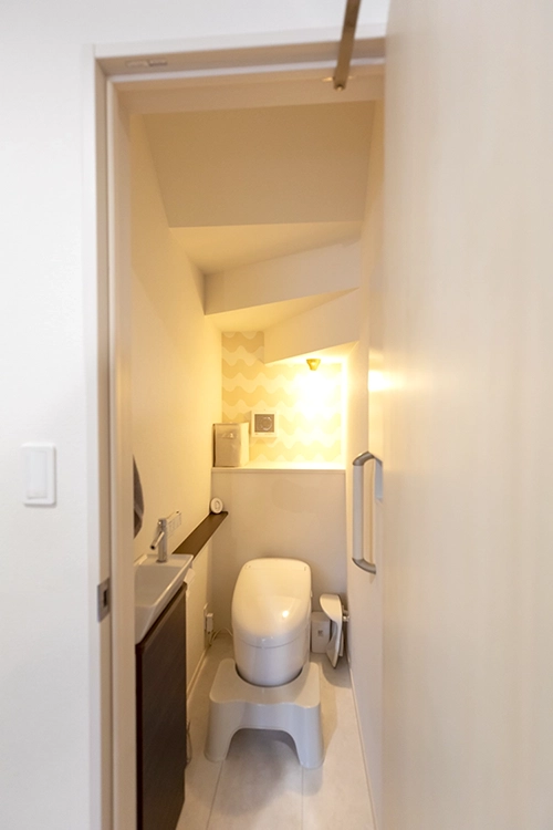 お手洗いの位置は、階段下のスペースを活用。明かりはOさまのセレクト