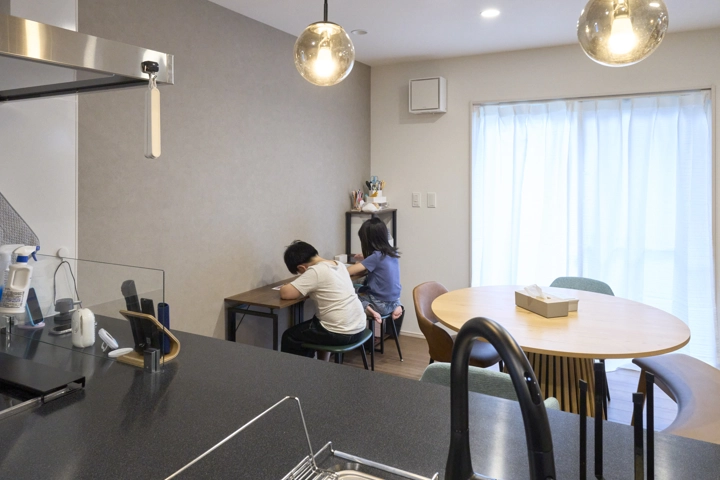 ダイニングのグレーのアクセントクロス側に設けた学習スペース。料理をしながらお子さまを見守れます