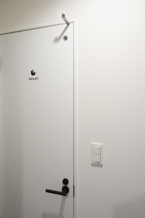壁と扉の基調は白、ドアノブやトイレマークは黒ですっきり統一。部屋の多い2階でも、お子さまのお友だちが迷いません